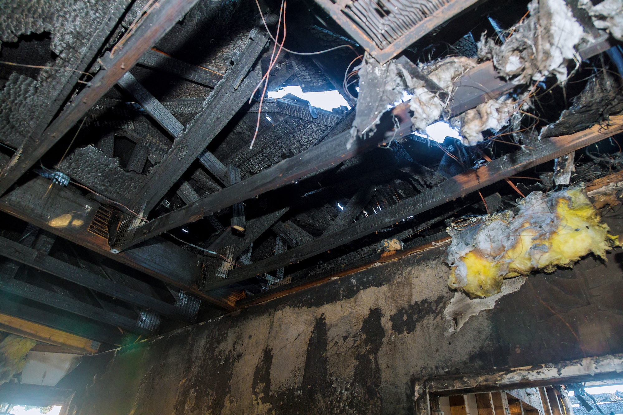 Burned house interior after fire burnt wooden poles walls