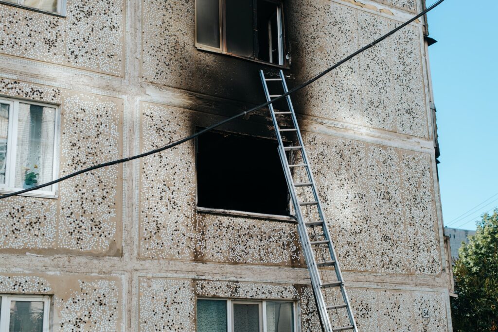 Burnt-out apartments, outside view. Black window in the soot from the fire and stairs